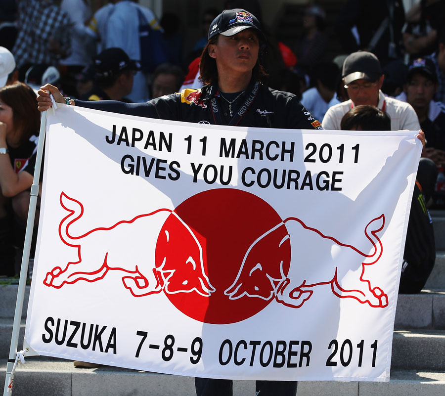A Red Bull fan unfurls a flag on Sunday morning remembering the earthquake which hit Japan