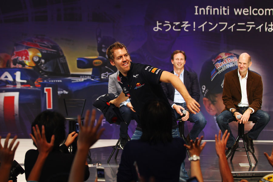 Sebastian Vettel throws his jumper in to the crowd at Nissan HQ after winning his second world championship
