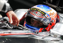 Jenson Button waits in the McLaren garage
