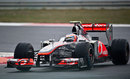 Jenson Button coaxes his McLaren around the damp circuit
