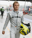 Nico Rosberg walks back to the pits after a collision at the pit lane exit