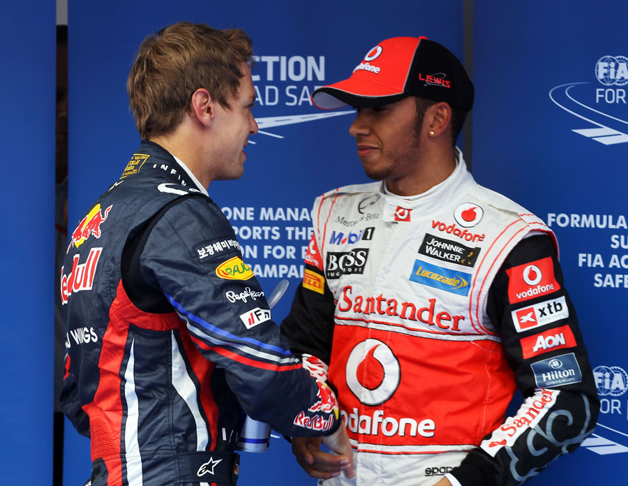 Sebastian Vettel congratulates a focused Lewis Hamilton on his pole position