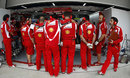 Ferrari crowd around the front of Fernando Alonso's car to conceal its new front wing