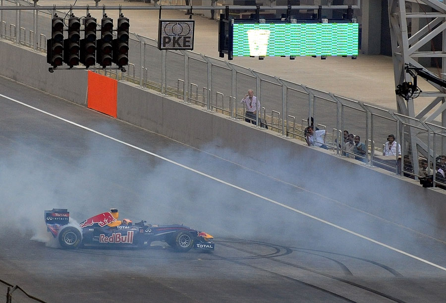 Neel Jani entertains the fans with donuts on the start/finish straight in the Red Bull showcar at the official unveiling of the new Buddh International Circuit