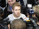 Sebastian Vettel at the centre of a media scrum at the Red Bull factory 
