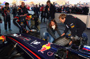 Sebastian Vettel helps change a tyre on the Red Bull show car