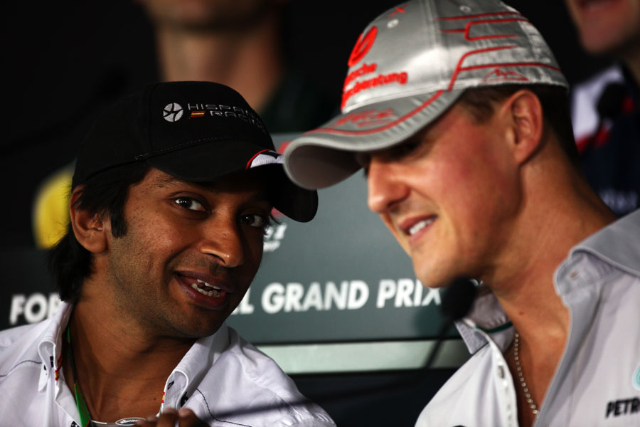 Indian driver Narain Karthikeyan talks to Michael Schumacher in Thursday's press conference