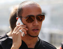 Lewis Hamilton chats on the phone during a track walk
