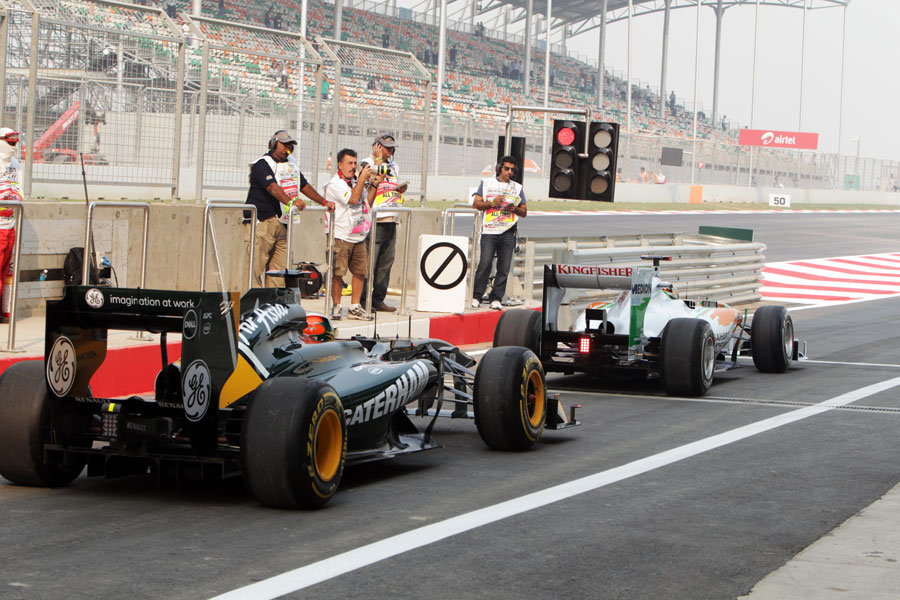 Adrian Sutil beats Karun Chandhok to the end of the pit lane