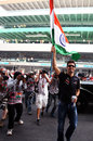 Mark Webber salutes the fans in the grandstand with an Indian flag
