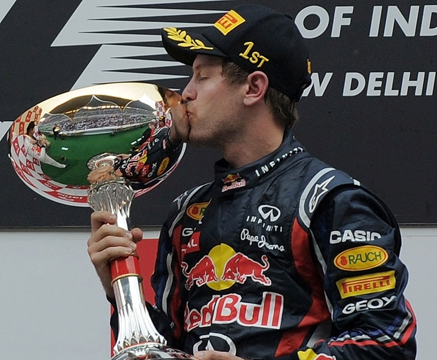 Sebastian Vettel celebrates with his winner's trophy