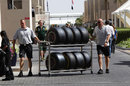 Mercedes mechanics wheel two sets of tyres down the paddock