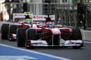 Felipe Massa follows Fernando Alonso down the pit lane