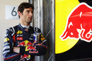 Mark Webber waits outside the Red Bull garage as his car is worked on early in FP3