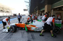 Adrian Sutil is wheeled back in to the Force India garage