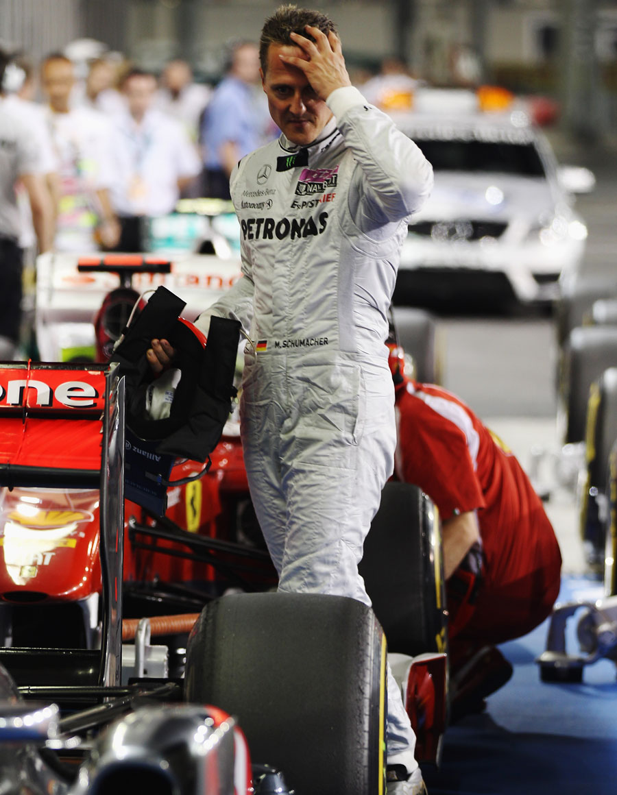 Michael Schumacher takes a look at the McLaren in parc ferme
