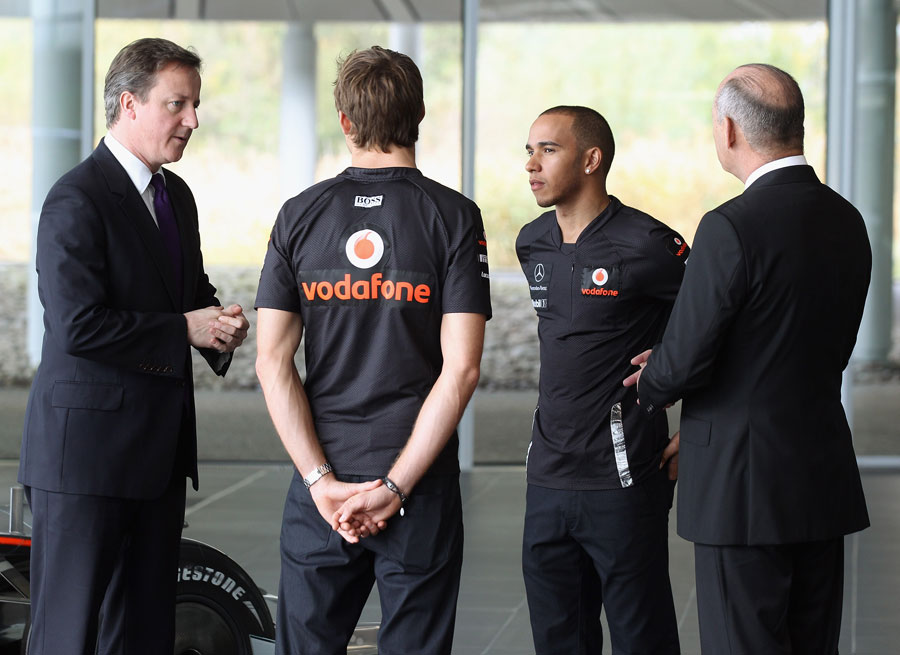 British Prime Minister David Cameron talks to Jenson Button, Lewis Hamilton and Ron Dennis during a visit to the McLaren Technology Centre