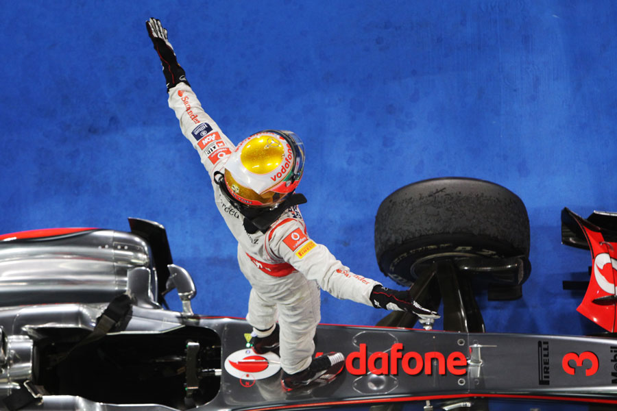 Lewis Hamilton celebrates on top of his McLaren
