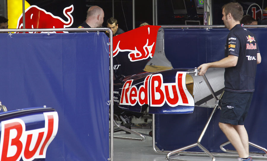 Red Bull mechanics move an engine cover for the RB7