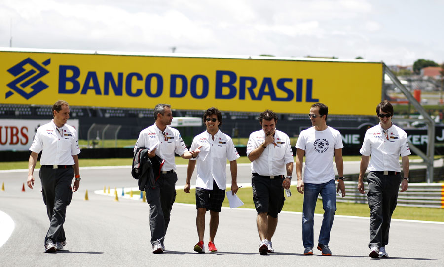Sergio Perez walks the track with his Sauber mechanics