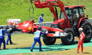 Fernando Alonso watches his Ferrari being lifted away