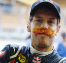 Sebastian Vettel celebrates beating Nigel Mansell's record for the most pole positions in one season by wearing a fake moustache