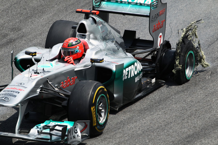 Michael Schumacher heads for the pits with a puncture