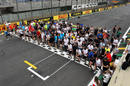 Members of the Formula One paddock run the track for charity