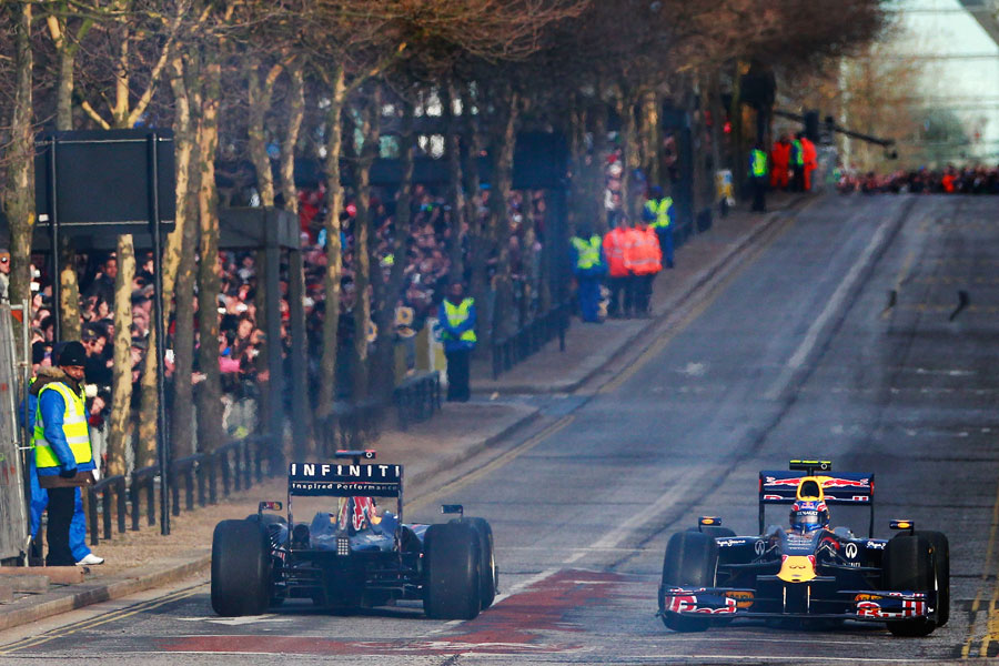 Mark Webber and Sebastian Vettel cross paths on a demonstration run