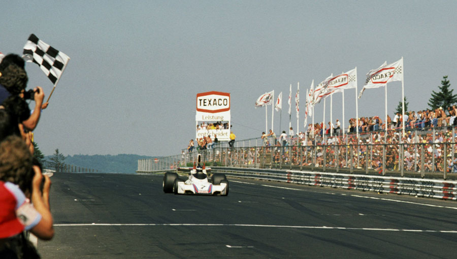 Carlos Reutemann celebrates as he takes the chequered flag
