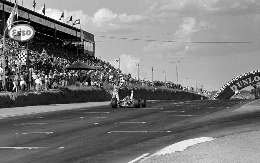Jim Clark crosses takes the chequered flag in the Lotus 49