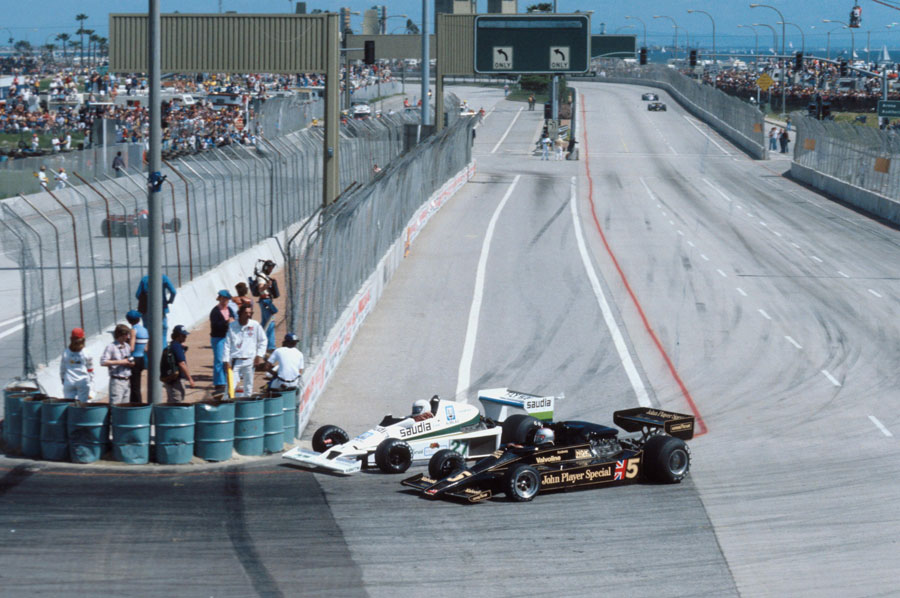 Alan Jones dives up the inside of Mario Andretti