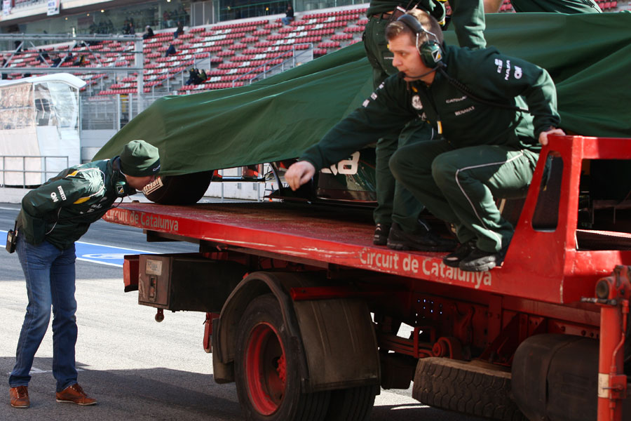 Vitaly Petrov sneaks a look at Heikki Kovalainen's Caterham as it returns to the pit lane