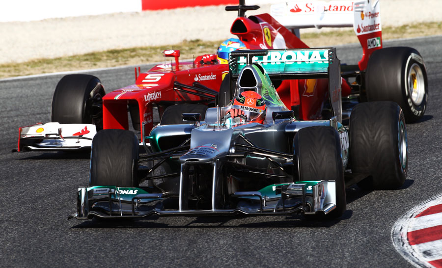 Fernando Alonso looks for a way past Michael Schumacher on intermediate tyres