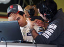 Sergio Perez talks to his engineer after Sauber discovered a problem with his car