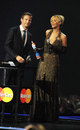 Jenson Button presents Rihanna with an award at the Brit Awards