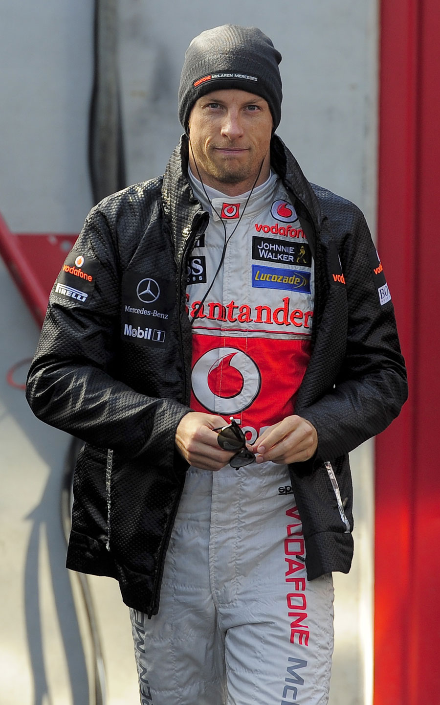 Jenson Button listens to music and tries to keep warm in the paddock