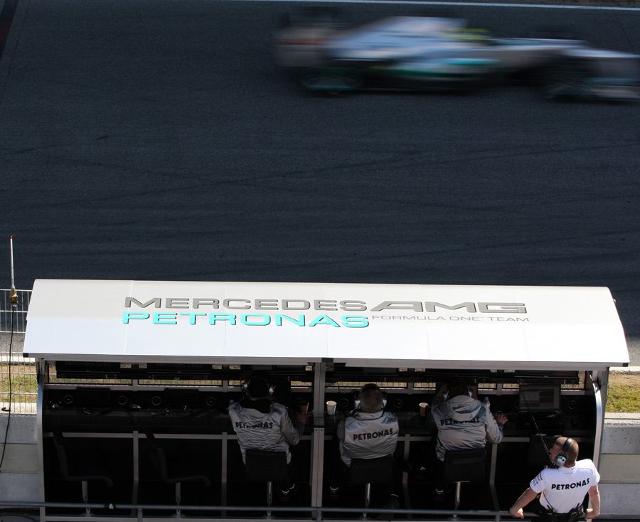 Nico Rosberg flashes past the Mercedes pits on Friday