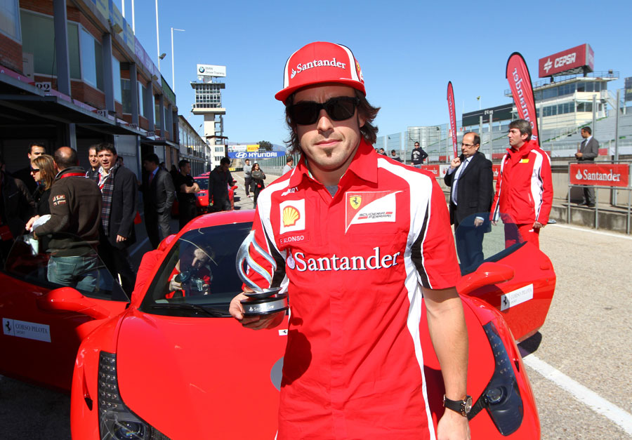 Fernando Alonso gets his hands on his first trophy of the season at a sponsor's event