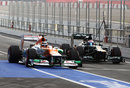 Vitaly Petrov passes Nico Hulkenberg at the end of the pit lane