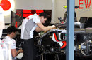 McLaren mechanics work on Lewis Hamilton's car