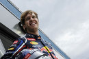 Sebastian Vettel smiles for the cameras in the paddock