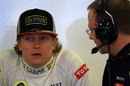 Kimi Raikkonen waits in the Lotus garage as his steering column is adjusted