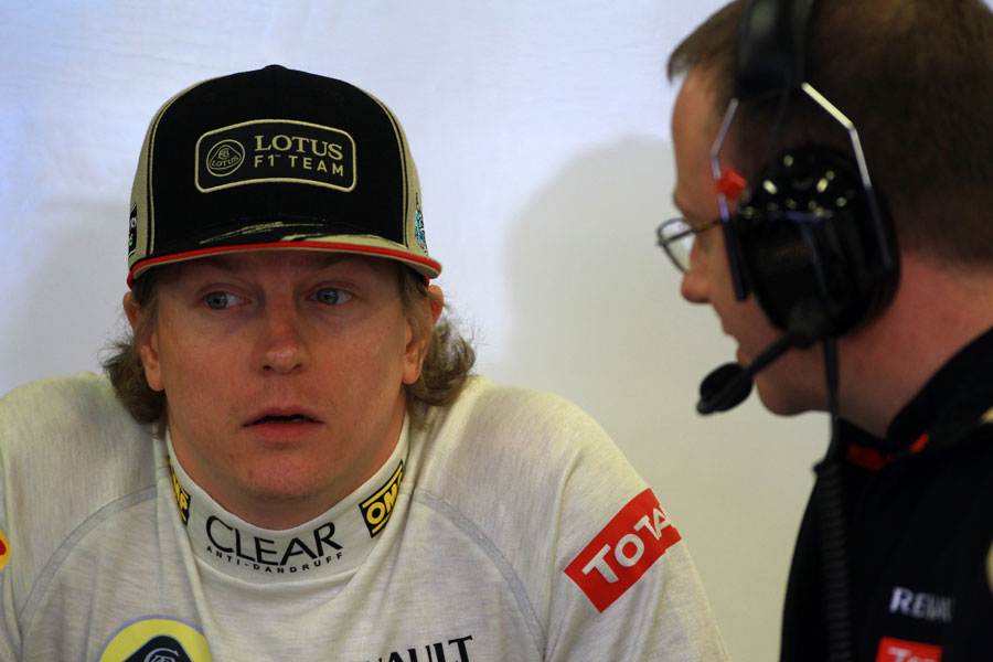Kimi Raikkonen waits in the Lotus garage as his steering column is adjusted
