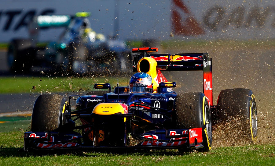 Sebastian Vettel skips across the grass at the first corner