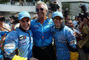 Flavio Briatore celebrates with Fernando Alonso and Jarno Trulli after locking out the front row