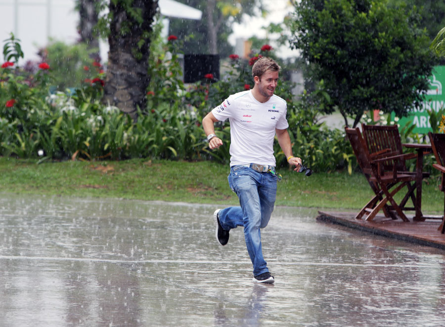 Mercedes third driver Sam Bird tries to find shelter from a torrential downpour on Thursday