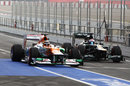 Nico Hulkenberg passes Vitaly Petrov in the pit lane