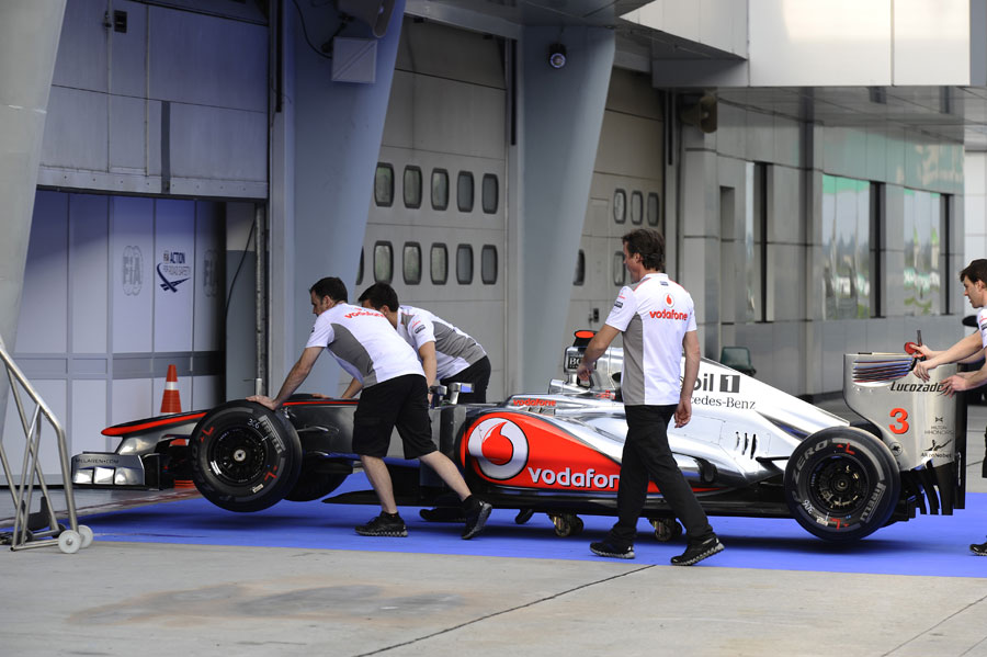 Sam Michael with McLaren engineers taking the MP4-27 to scrutineering