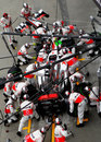 McLaren mechanics replace the front wing on Jenson Button's car